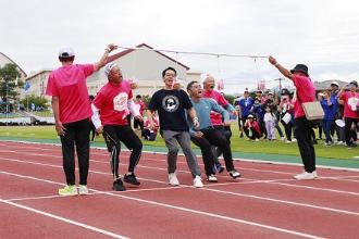 写真：ぱん食い競走試走式の様子。市長、木村さん、為末さん、黒崎さんが大きな口を開けてあんパンにかぶりつこうとしています