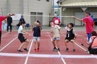 写真：小学生4人がぱんを取ろうと、口を大きく開けています