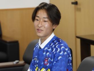 写真：ビーチサッカークラブフュージョン高橋選手。にこやかな表情で抱負を話しています