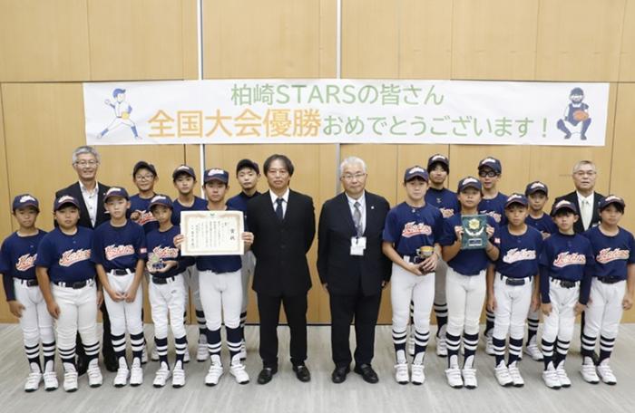 写真：柏崎スターズの集合写真。選手が賞状や盾を持っています