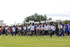 写真：ガールスカウト新潟県第1団の皆さんが列の先頭でプラカードを持ち、参加者が入場行進をする様子