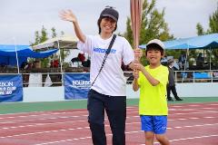 写真：第三走者の柏崎ファンクラブ会員の平井さん親子。お母さんがこちらに向かって手を振っています