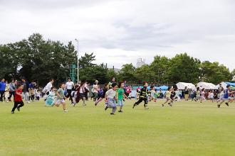 写真：幼児レース中の様子です。大勢の子どもたちがゴールに向かって走っています。