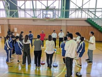 写真：参加者がカローリングのポイントゾーンに集まり、スポーツ推進委員の説明を聞いています