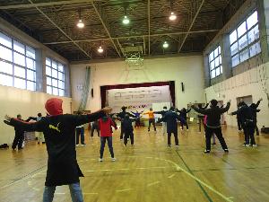 写真：参加者がラジオ体操をしていて両手をあげ胸を反らす運動をしています