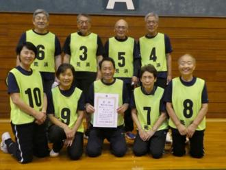 写真：第2位の荒浜チームの記念写真。9人のメンバーが前後に並び、中央の男性が賞状をこちらに向けています