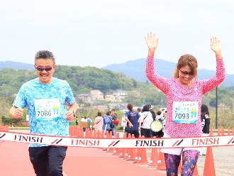 写真：男性と女性がそれぞれゴールした様子です。2人とも笑顔でゴールしています