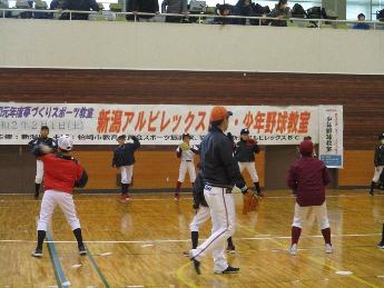 キャッチボールをする小学生たちの周りを歩く小野投手の写真