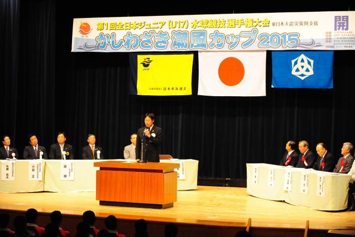 日本水泳連盟会長がステージ中央であいさつしている写真