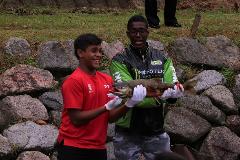 写真：シンガポールの選手が二人で1匹の鮭を持っています