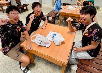 写真：浜焼きにかぶりつく男子選手