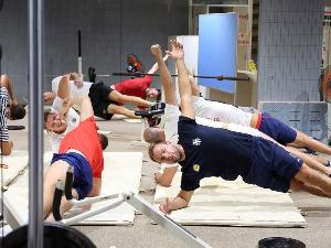 写真：サイドプランク（横向きになり、肘を肩の真下について体を起こすポーズ）を行うセルビア共和国の選手