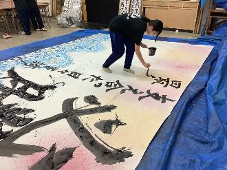 写真：「最後まで」と書いている高校生