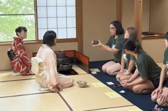 写真：木村茶道美術館でお点前をいただく選手たち。正座をして一列に並び、奥の選手が国宝級の茶碗を両手で持って眺めています。