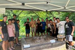 写真：にじますを焼きながら、焼き台を囲んで記念写真