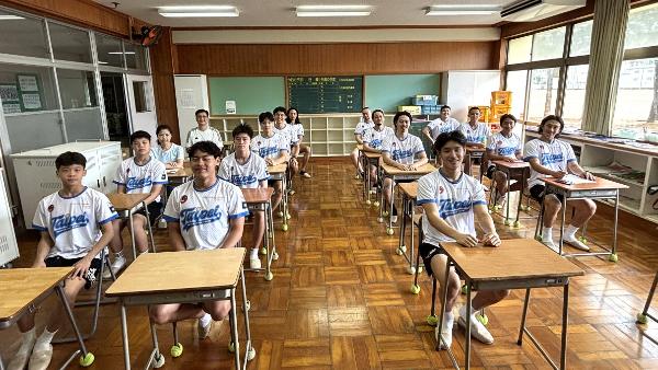 写真：空き教室で椅子に座って記念撮影する台北市代表隊の皆さん
