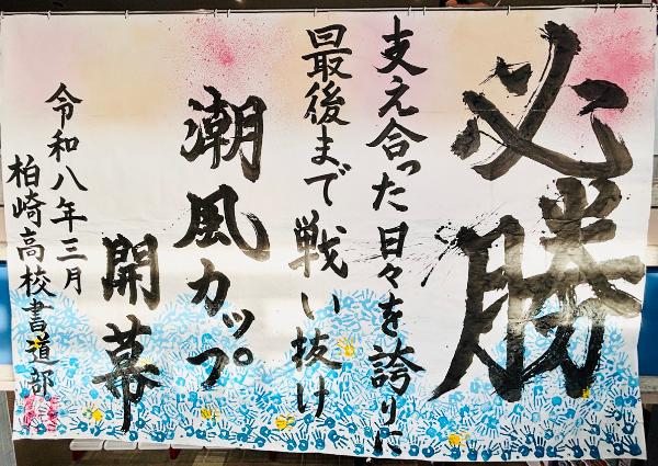 写真：必勝、支え合った日々を誇り人最後まで戦い抜けとメッセージが記されています。また、作品の市は半分には、水面を連想させるようないくつもの青系グラデーションの手形が押されています。