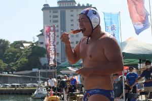 写真：試合中に岸にあがり、浜焼きを食べる作田選手