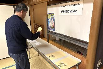 写真：大会実行委員会の委員がブロック名が書かれた紙を封筒に入れています