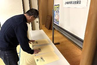 写真：大会実行委員会の委員が封筒の順番をシャッフルしています