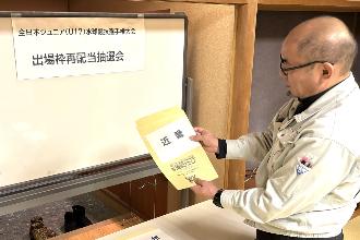 写真：大会実行委員が2つ目の封筒を選び、近畿ブロックを引きました