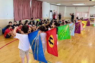 写真：色とりどりの旗を持ちながらダンスを披露する園児
