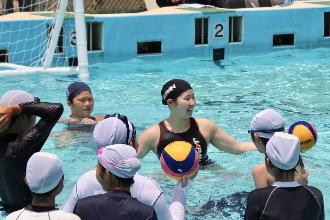 写真：選手がボールを持って児童へ説明しています