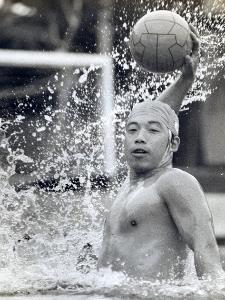 写真：プレー中の矢島さん。水しぶきを上げ、ボールを持った右腕を大きく振りかぶっています