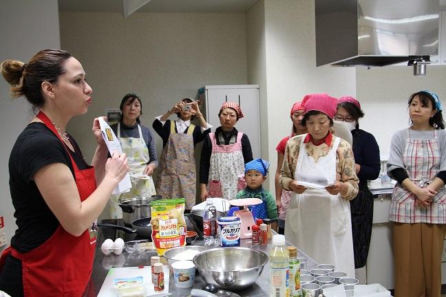 参加者に料理の説明を行う長門ティヤナさんの写真