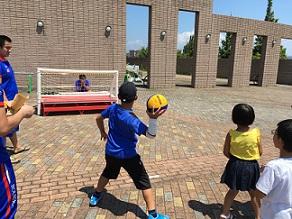 男の子が水球ボールを勢いよく投げようとしている様子の写真