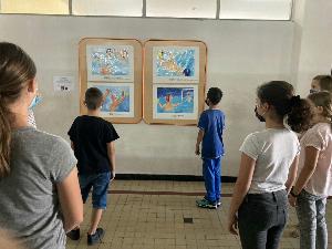 写真：6名の児童が間隔を空けて絵画を見ています