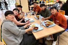 写真：産大水球部の選手とシンガポールの選手が同じテーブルでランチを食べています