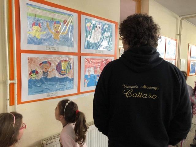 モンテネグロの水球選手が壁に飾られている絵画を見ている写真