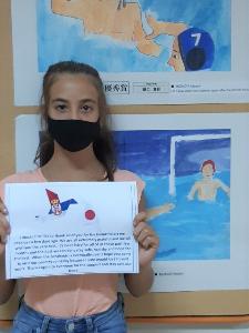 写真：メッセージが書かれた紙を持った女子児童