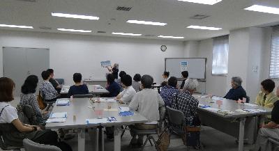 写真：グループごとに机を合わせ、読み聞かせを聞いている様子。