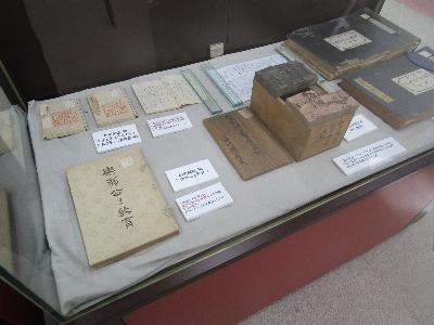 写真：ガラスケースの中に松平定信関連の資料（印刷本や新聞スクラップ、判木）が展示しされています