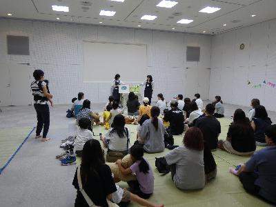 写真：2人の職員が大型絵本を読み聞かせている様子。