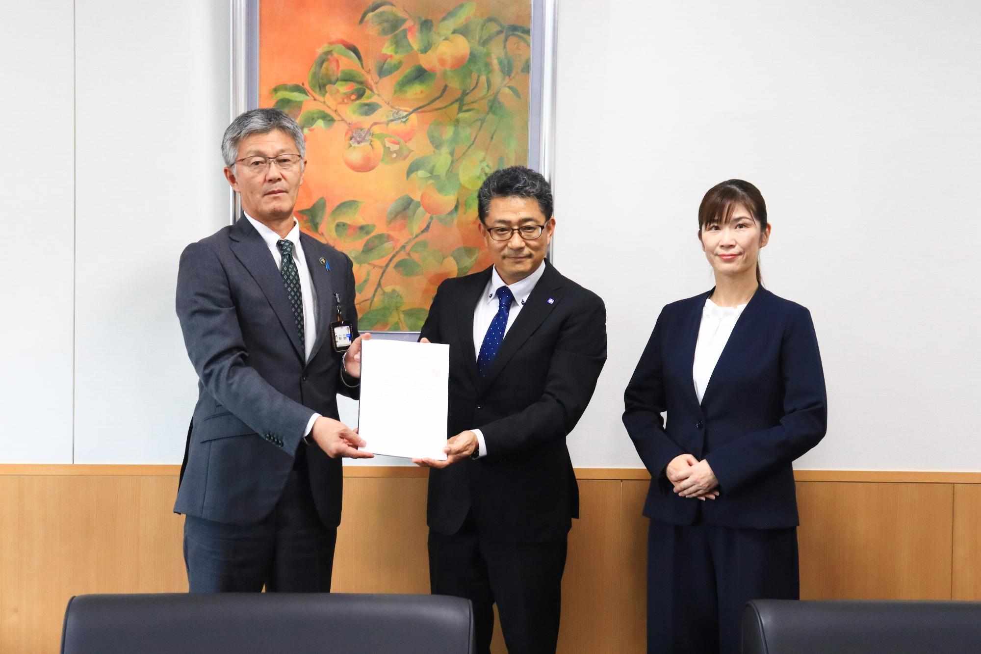 答申書を受け取った市長と並ぶ総合計画審議会の正副会長