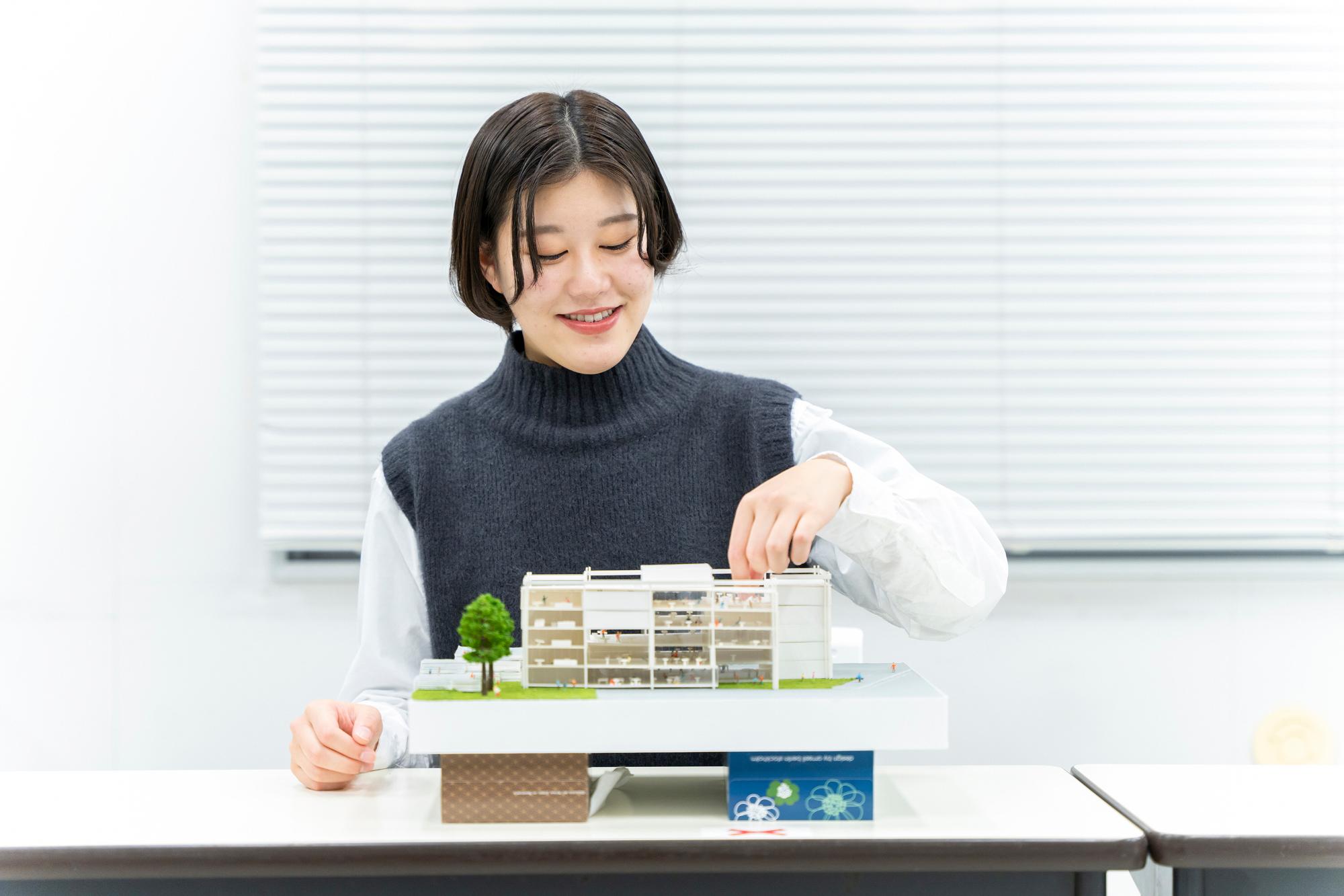 新潟工科大学の学生1名が、楽しそうに建築模型を作成している写真