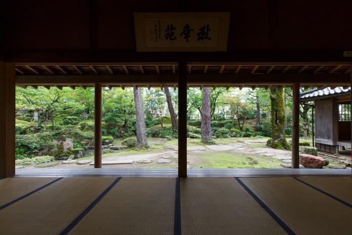 庭園にはたくさんの木々や緑が賑わい見た目でも癒される飯塚邸の座敷から見える秋幸苑の写真