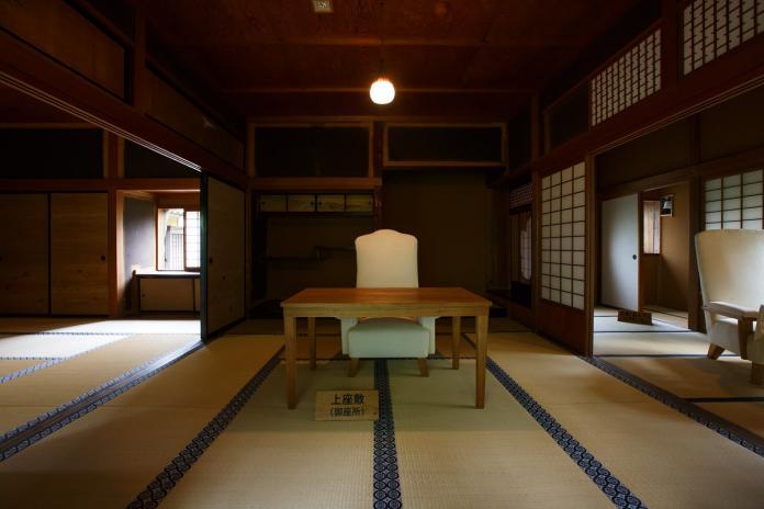 畳の大広間には昭和天皇が使われたという白い布が掛けられた椅子と机が置かれている飯塚邸の行在所の写真