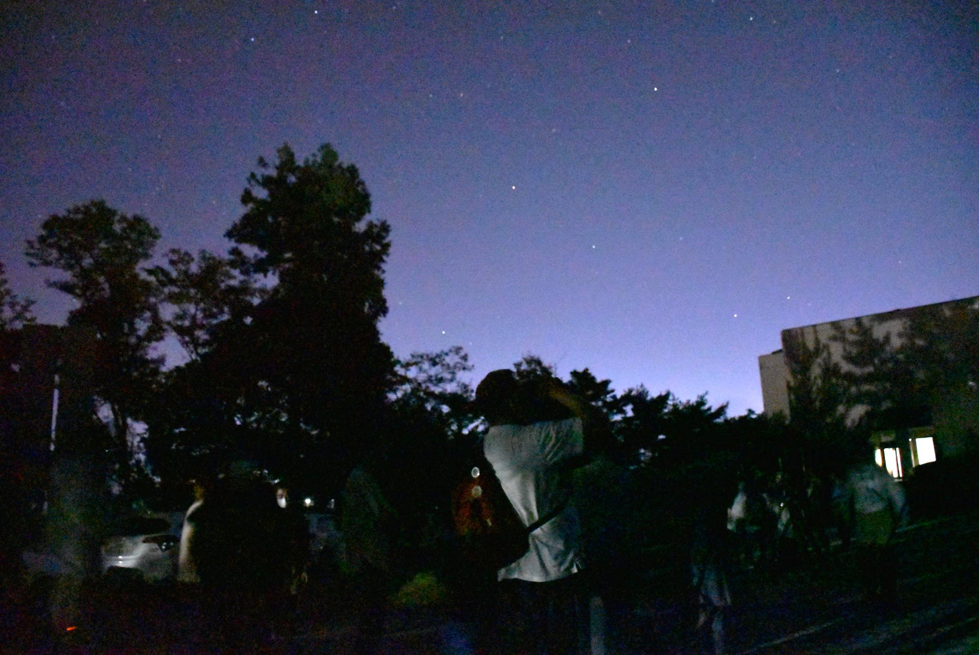 写真：望遠鏡や双眼鏡使い、天空を見上げて惑星や星雲を観察する参加者