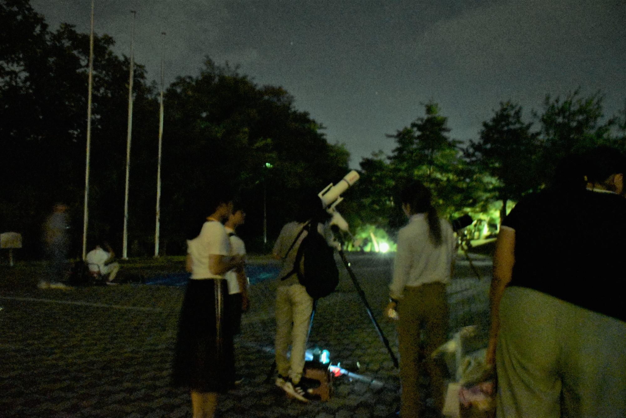 天体望遠鏡を使って、星空を観察するようすの写真
