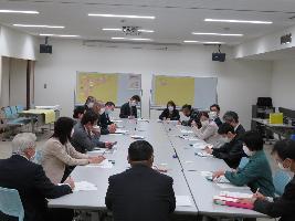 写真：産業文化会館の第5・6会議室で行われた昨年の意見交換会。18人と大きなグループで話し合っています。