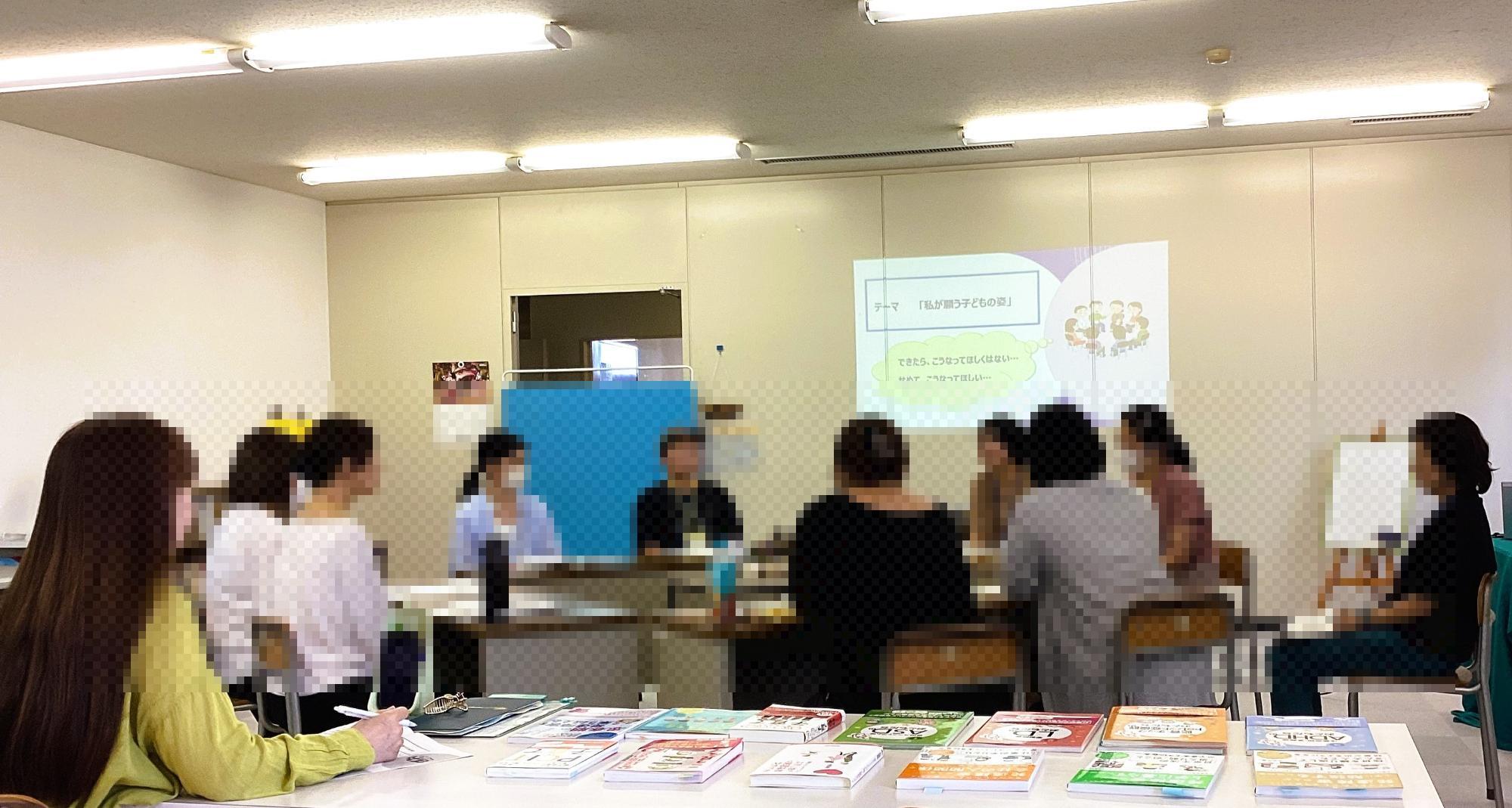 写真：第1回講座の様子。参加者が机を丸く並べて、座談会形式で話しています。