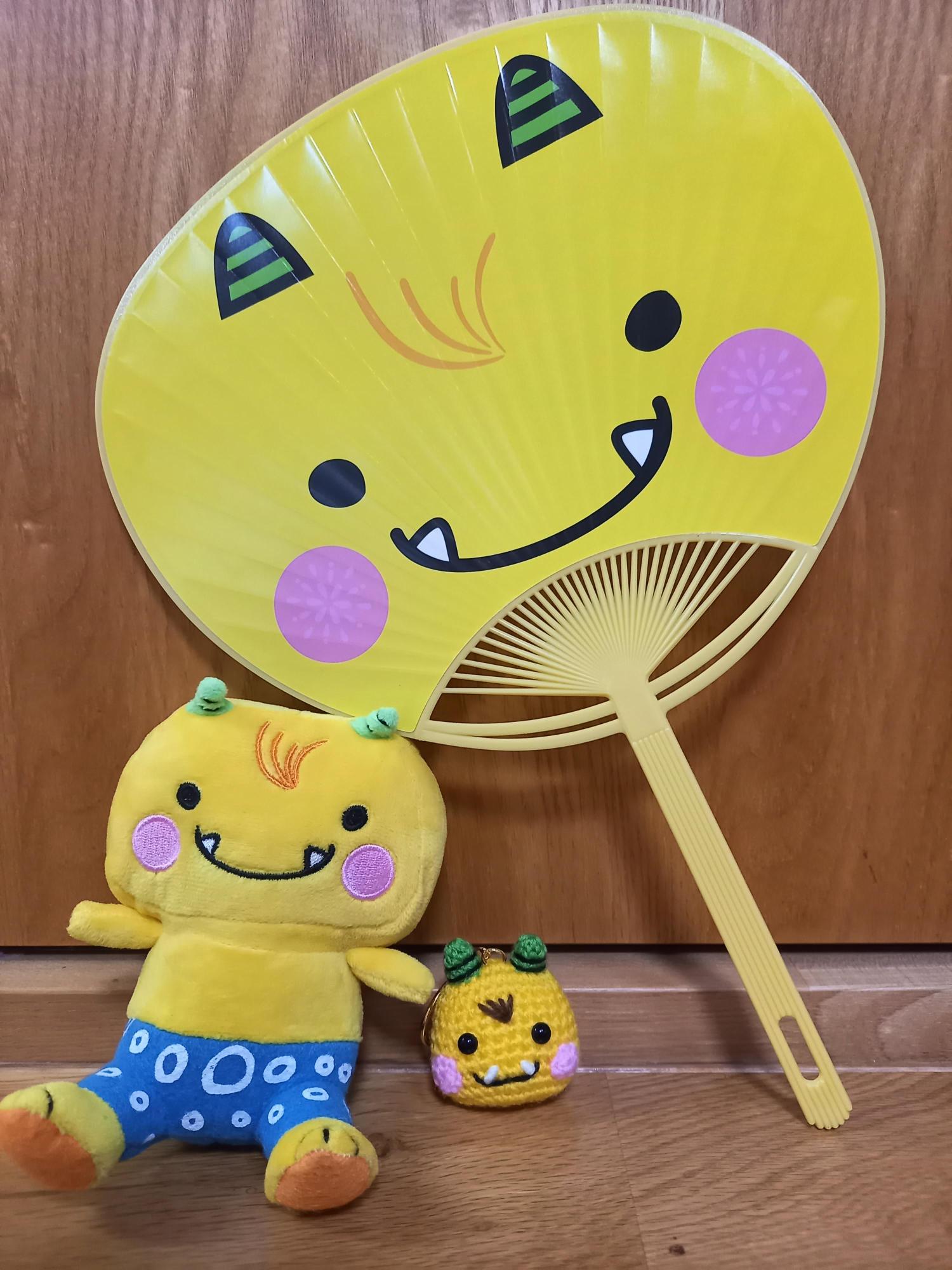 写真：越後PRキャラクターのえちゴンのうちわとぬいぐるみ。えちゴンは黄色の小鬼のキャラクターです。