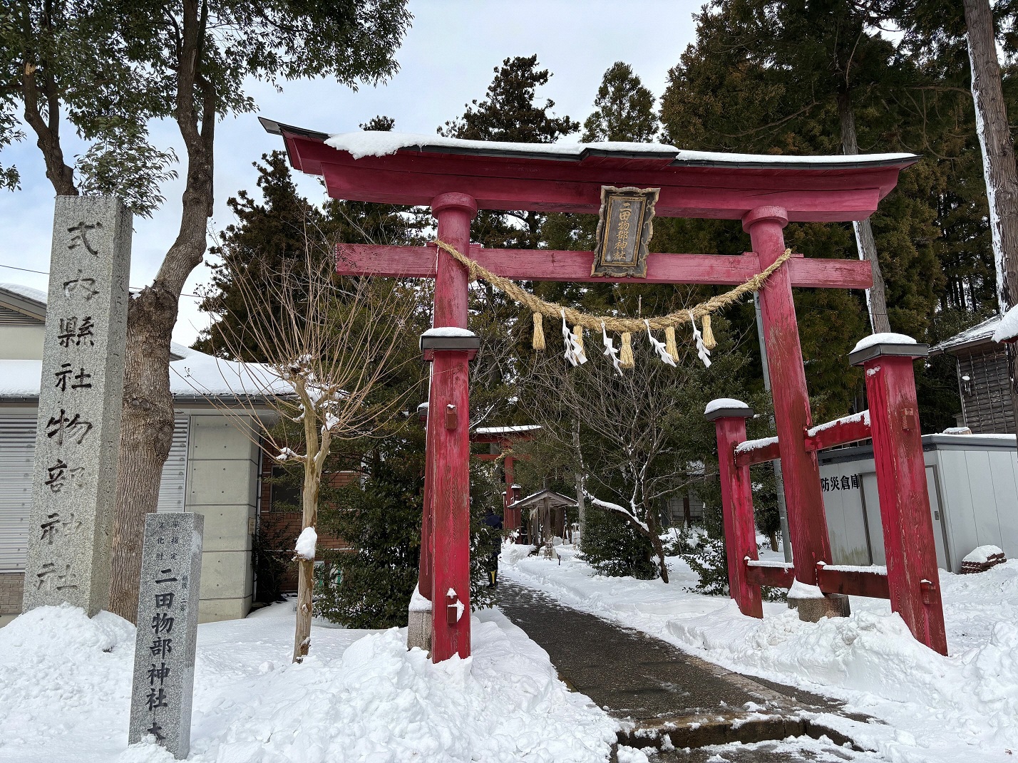 写真：雪に埋もれた二田物部神社の赤い鳥居。本堂に続く参道はきれいに除雪されています