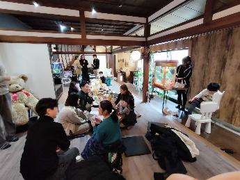 参加者が鯛焼きとコーヒーをいただきながらおしゃべりしている