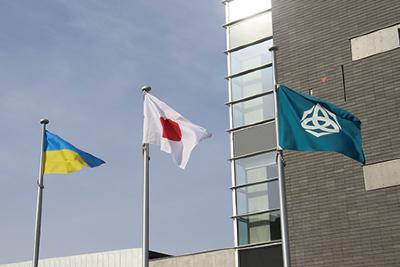 写真：青空の下、柏崎市役所の前で風になびく日本とウクライナの両国旗と柏崎市の旗