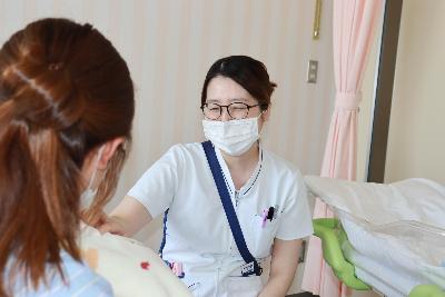 写真：産後ケアを利用している母子に、笑顔で対応する病棟スタッフ